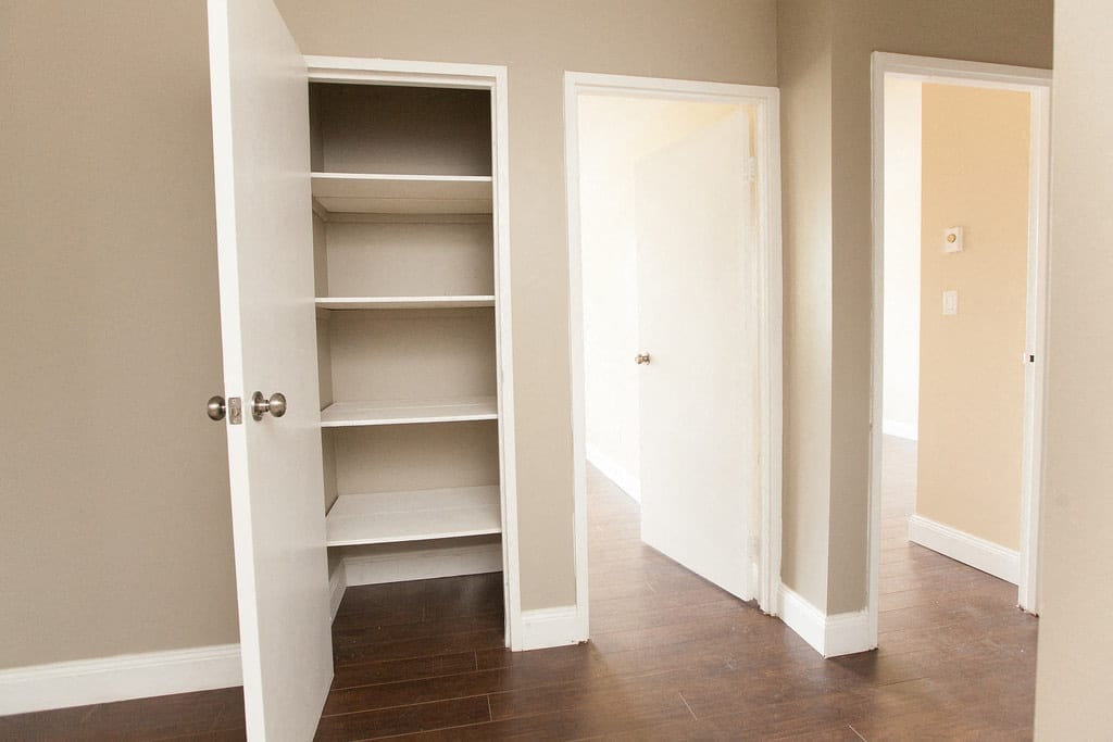 Suite hallway with a shelved linen closet and the bedroom doors